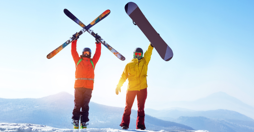 Narciarz i snowboardzista trzymają narty oraz deskę snowboardową w górze na ośnieżonym stoku