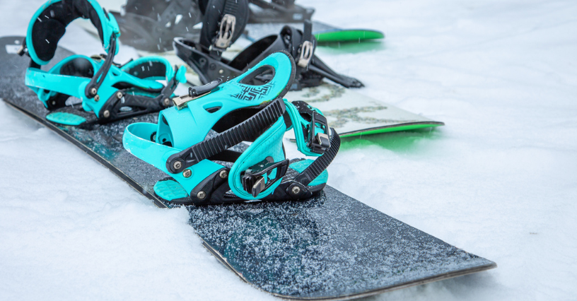 Deska snowboardowa z kolorowymi wiązaniami leży na śniegu