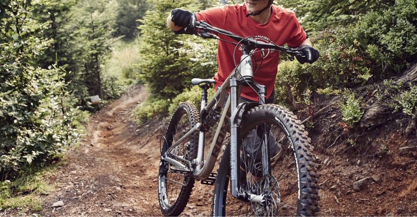 Mężczyzna prowadzący pod górę rower MTB