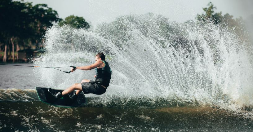 Wakeboarder jadący po wysokiej fali na desce