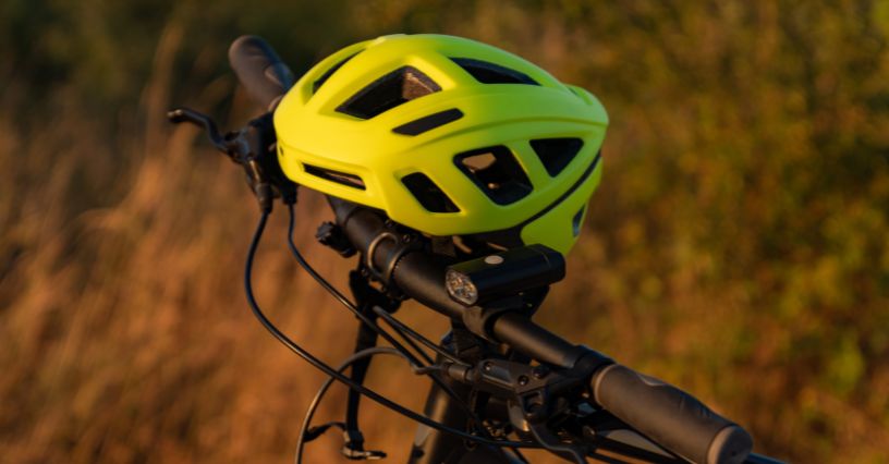 Kask rowerowy położony na kierownicy roweru