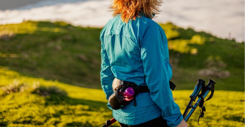 Turystyka z kijkami z zapiętą na biodrze saszetką turystyczną