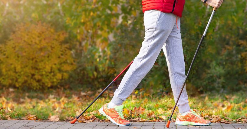 Kijki do nordic walking trzymane w czasie chodzenia po chodniku